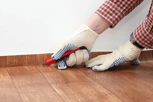 Construction worker cutting linoleum